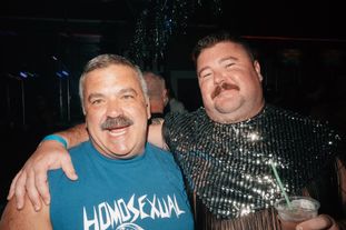 Two men in a club smiling for the camera