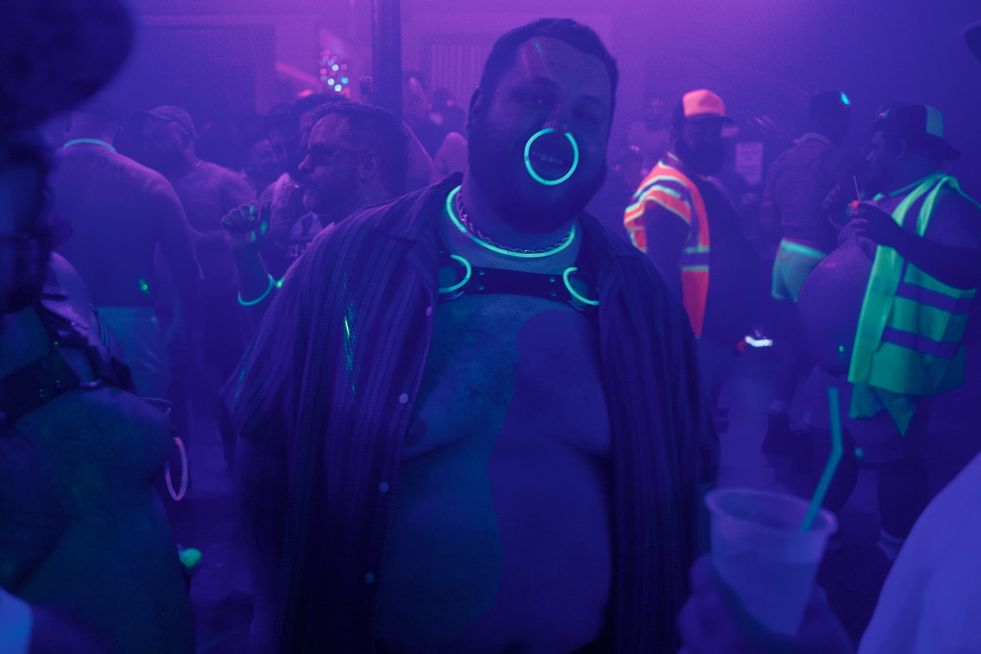 A man in a club with a large, glowing nose ring
