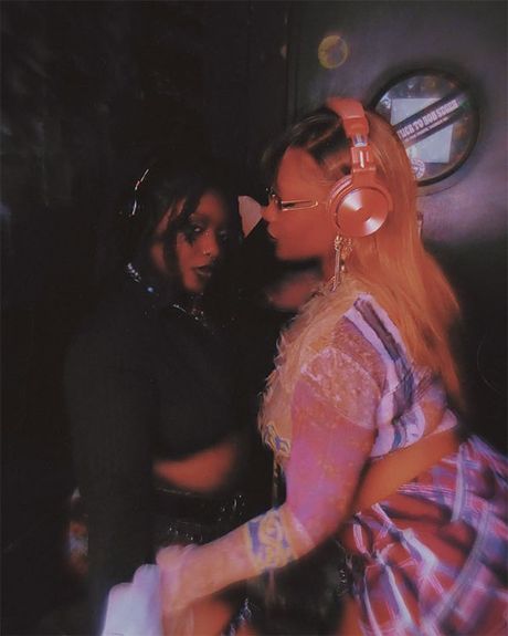 Two women wearing headphones embracing each other sexually