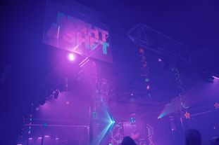 Interior of a club. A sign hanging displaying the Night Shift logo