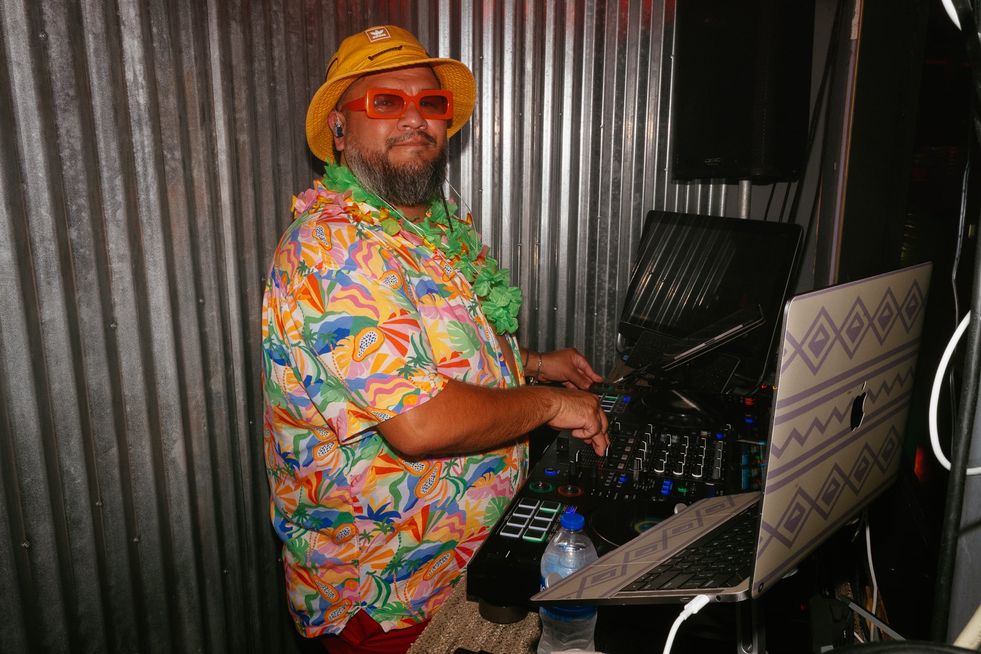 A DJ in beach apparel in the DJ booth