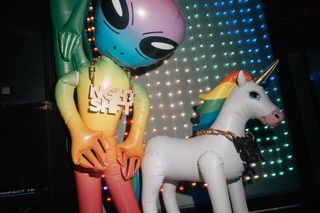 An alien and unicorn prop. The alien has a gold chain with the Night Shift logo