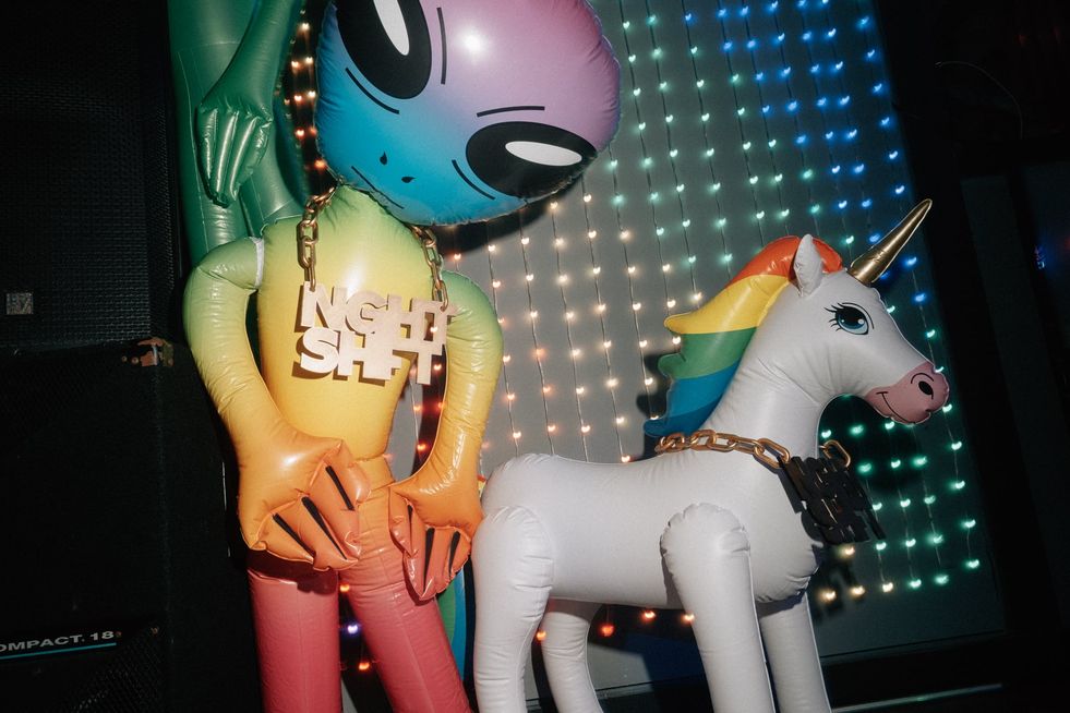 An alien and unicorn prop. The alien has a gold chain with the Night Shift logo